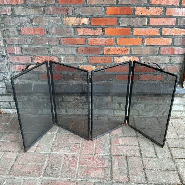 Vintage iron quad-fold firescreen for fireplace safety and style.