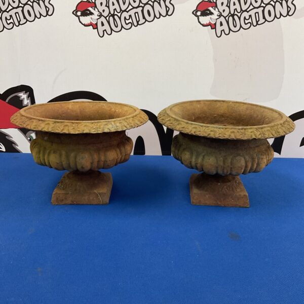 Pair of antique Victorian cast iron urn planters for garden display.