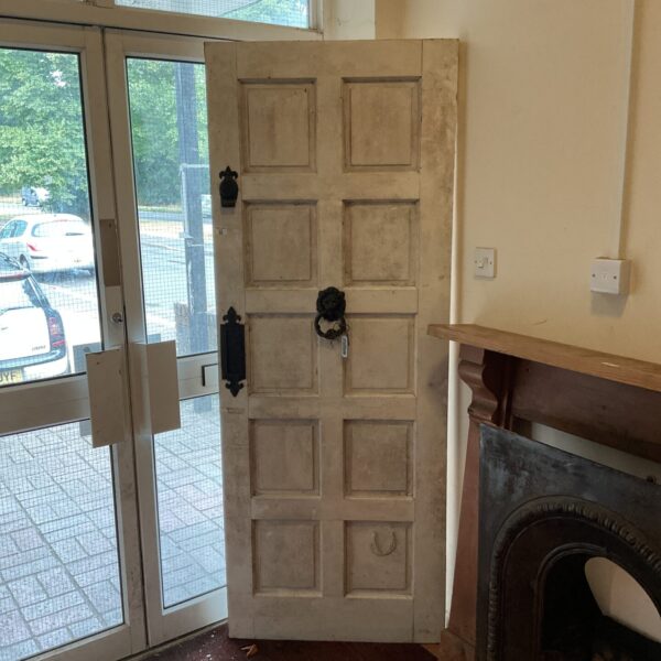 Antique wooden front door with lion head knocker, vintage architectural detail.