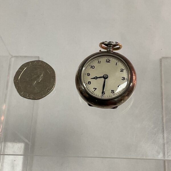 Vintage 935 silver ladies pocket watch with a coin for scale.