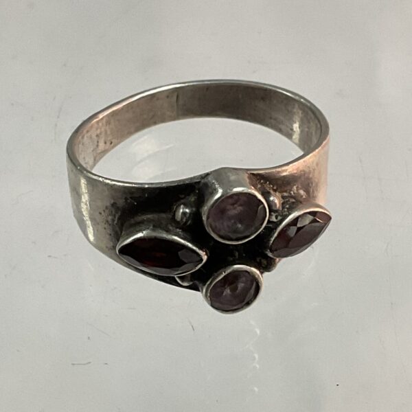 Silver ring with ruby and amethyst gemstones, size O.