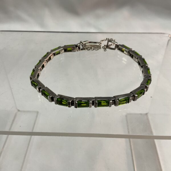 Close-up of a green peridot and silver bracelet.