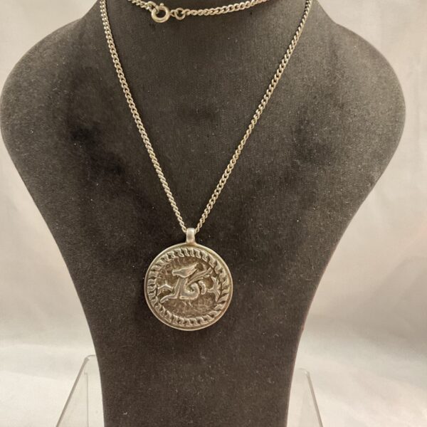 Detailed silver dragon pendant on a silver chain.
