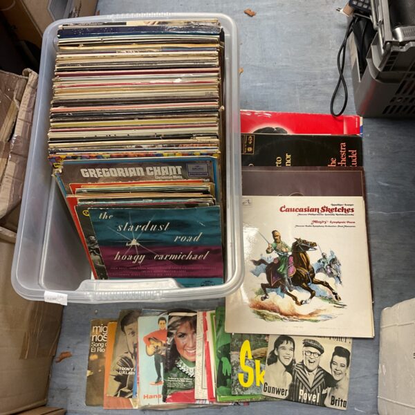 Assorted vintage vinyl records in a storage box, a diverse record lot.