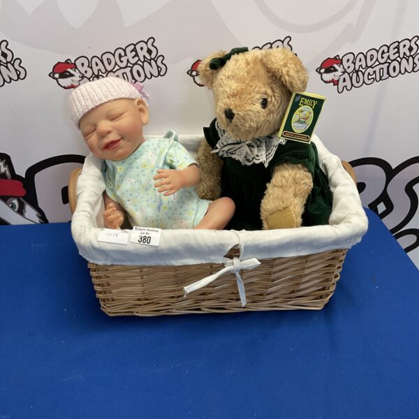 Vintage baby doll and Emily teddy bear in wicker basket.