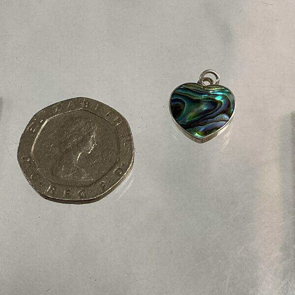 Close-up of a silver pendant with iridescent abalone shell.