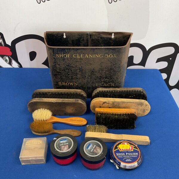 Vintage shoe cleaning kit in a metal tin with brushes and polish.