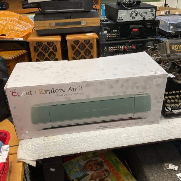 Cricut Explore Air 2 cutting machine in box, crafting equipment.