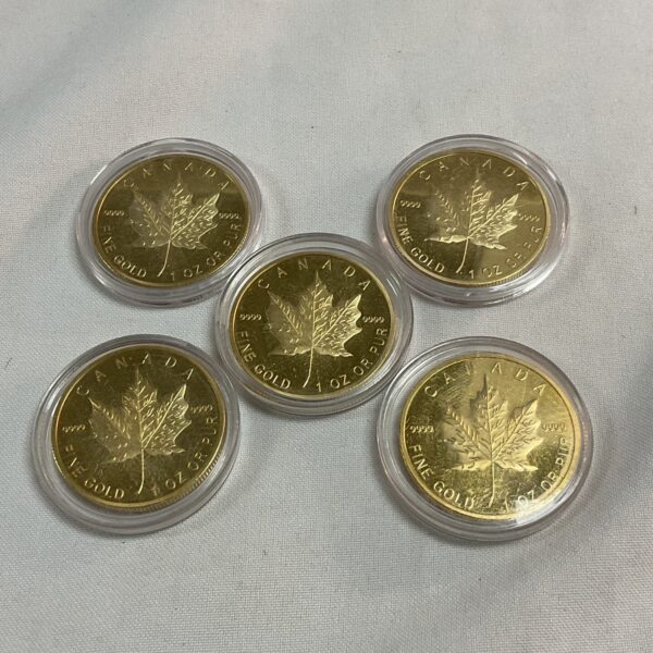 Lot of five replica Canada 50 dollar coins in gold tone.