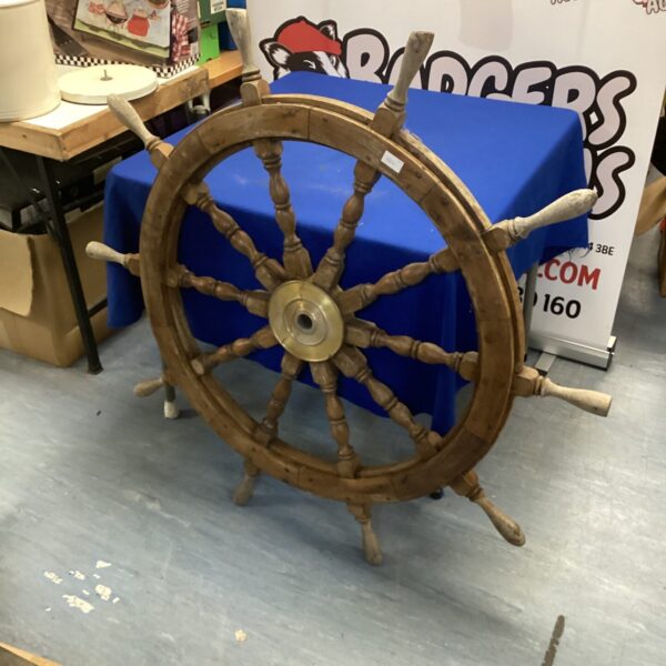 Large vintage ships helm with wooden spokes.