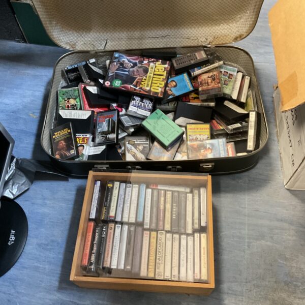 Vintage cassette tape lot in a carrying case, 1980s music collection.