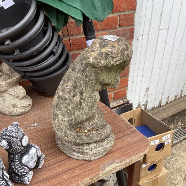 Detailed concrete otter garden ornament for outdoor display.
