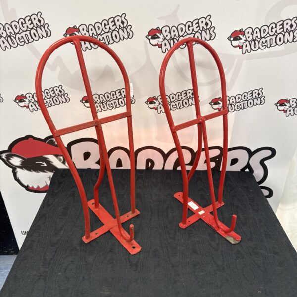 Two metal wall-mounted horse saddle racks for equestrian storage.
