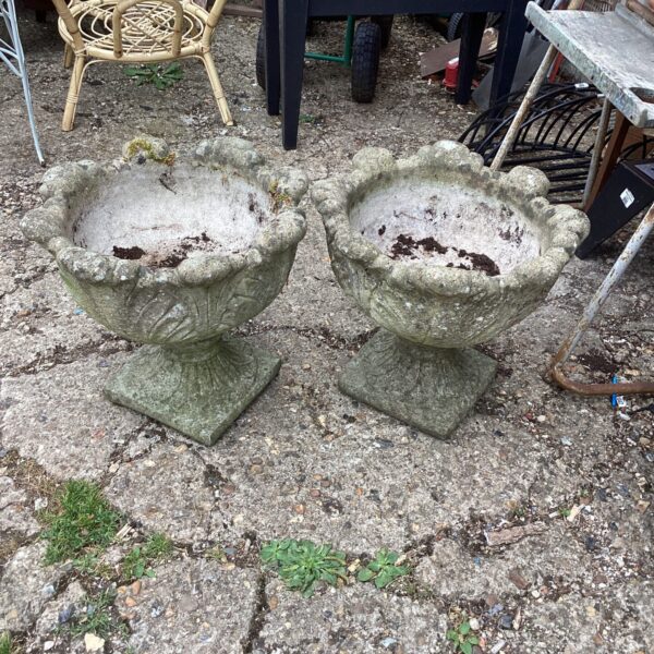 Pair of weathered stone effect garden planters for outdoor use.