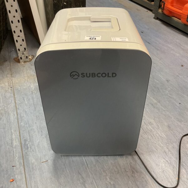 Grey Subcold mini fridge standing on a concrete floor.