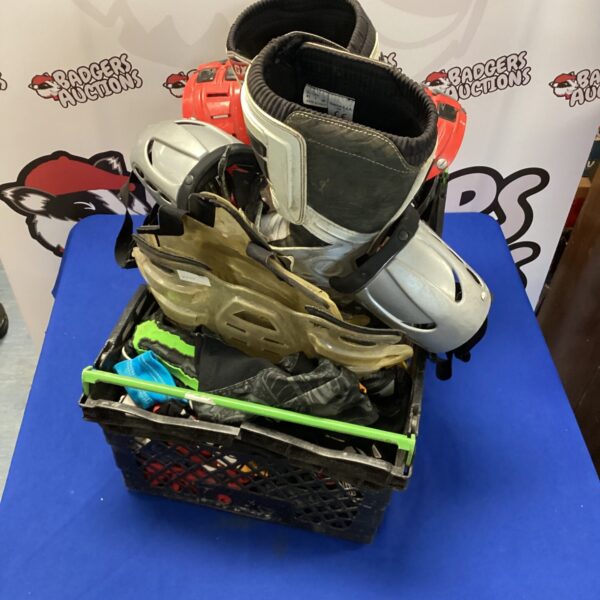 Crate filled with motocross gear including armour and boots.