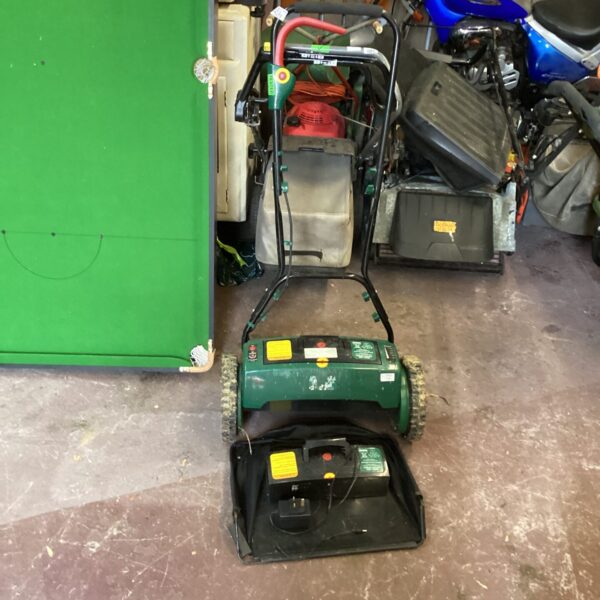 Used battery lawn mower with spare battery and charger for garden maintenance.