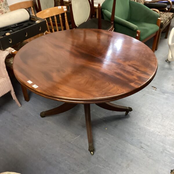 Antique mahogany tilt top table with curved legs.