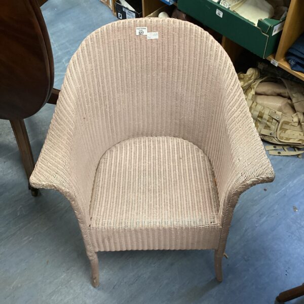 Vintage pink woven bedroom chair with curved back.