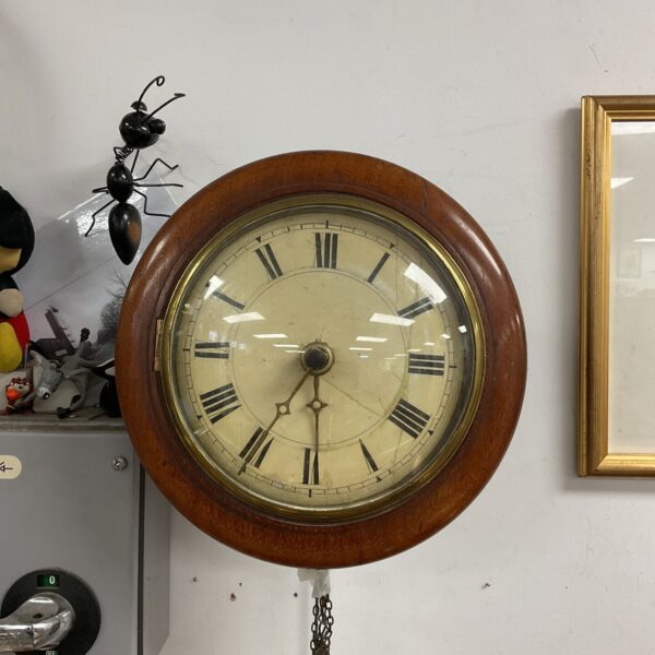 Antique striking wall clock with white enamel dial.