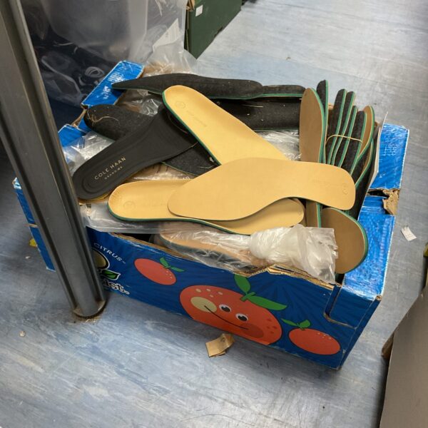 Large quantity of neutral-coloured shoe insoles for comfort and support.