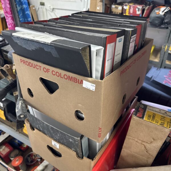 Two boxes filled with assorted ring binders for office organisation.