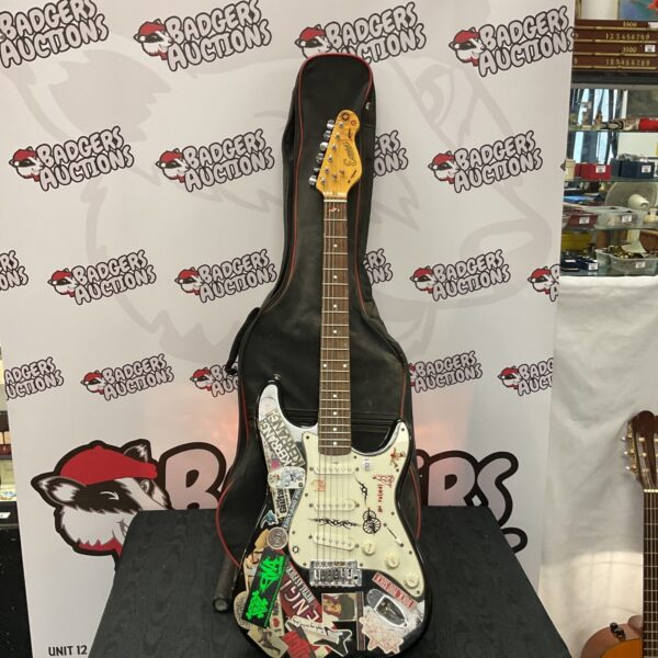 Black Encore electric guitar with case, showing wear and tear.
