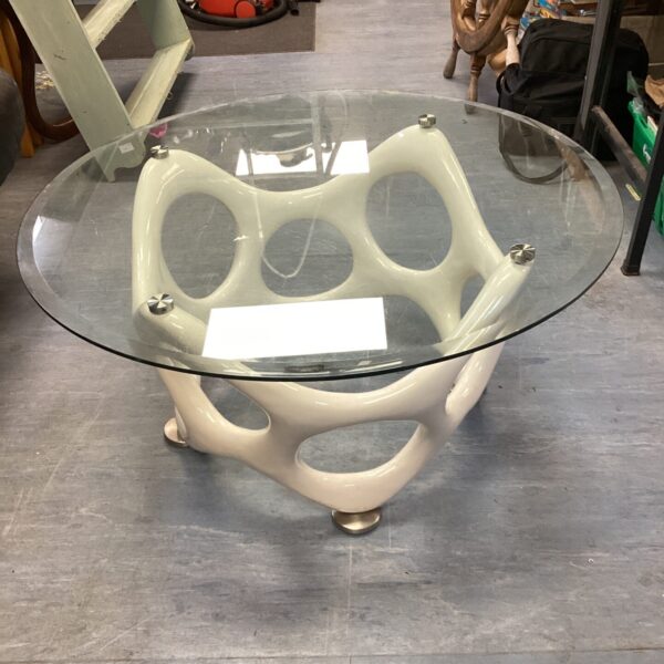 Modern glass coffee table with sculptural white base.