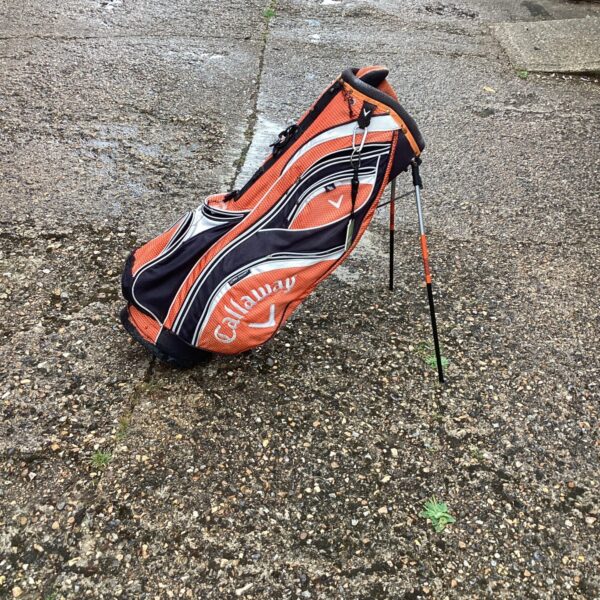 Orange and black Callaway golf stand bag on a grey surface.