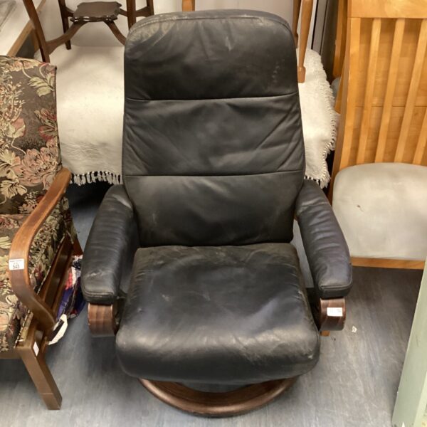 Black leather Himola gents swivel recliner chair in a vintage setting.