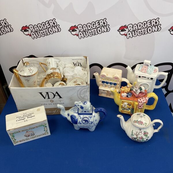 Vintage novelty teapots and Japanese teaset collection on display.