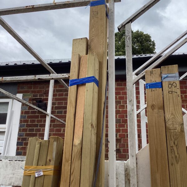 Three bundles of timber secured with blue strapping outdoors.