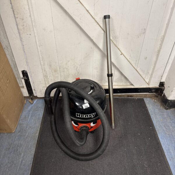 Red Numatic Henry Hoover with hose attachment.