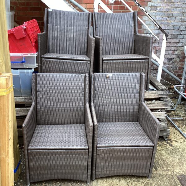 Four rafia effect garden chairs in a garden setting.