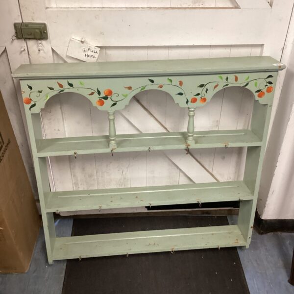 Green painted pine plate rack for displaying kitchenware.