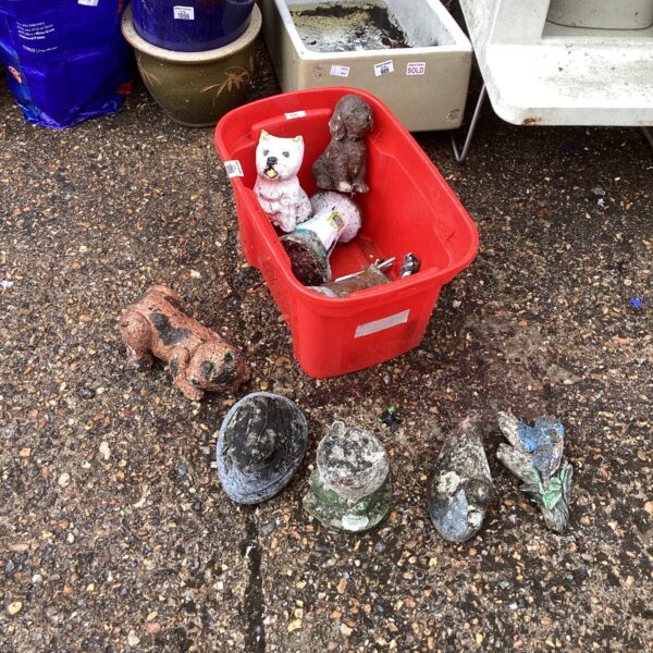 A collection of vintage concrete garden ornaments in a lot.