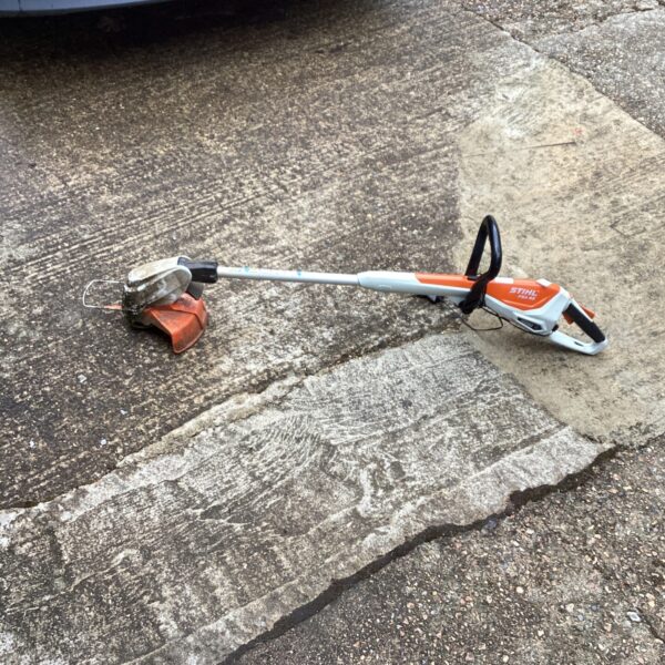Close-up of a used Stihl battery strimmer for garden maintenance.