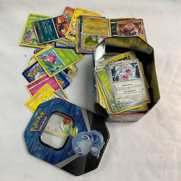 Assorted Pokemon cards inside a metal tin.