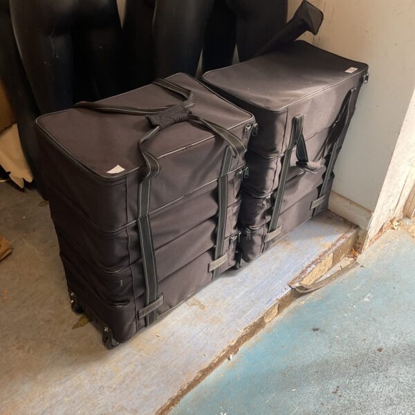 Two black wheeled storage cases stacked, showing wheels and handles.