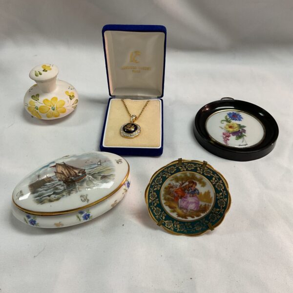 Vintage Limoges porcelain collection with plates, pots, and pendant.