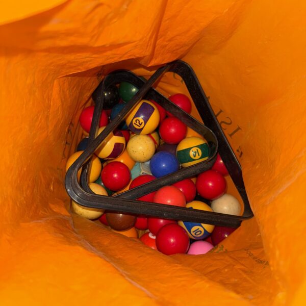 Vintage pool and snooker balls in a bag with racks.