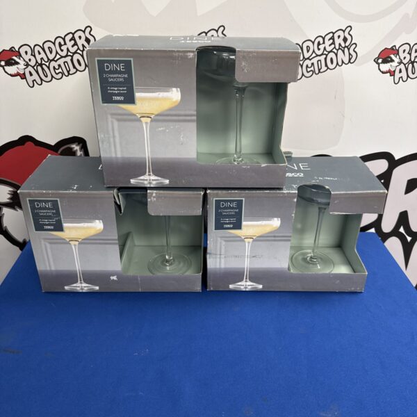 Three sealed twin packs of Tesco champagne saucer glasses.