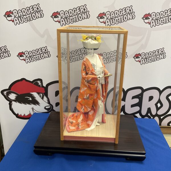 Vintage Japanese Geisha doll in a display case.