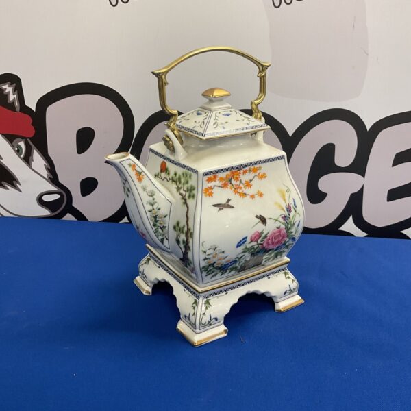 Vintage Japanese porcelain teapot with oriental scenes and gold accents.