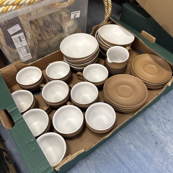 Lot of Denby stoneware cups, saucers, and bowls on display.