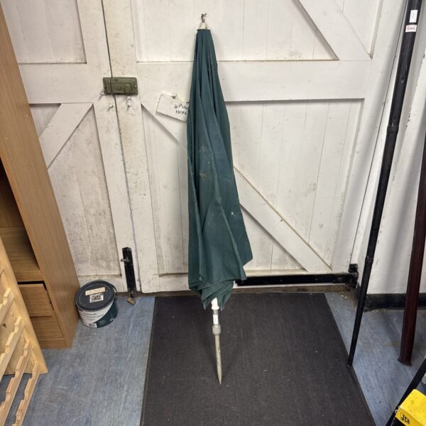 Angled view of a used fishing brolly against a wooden door.
