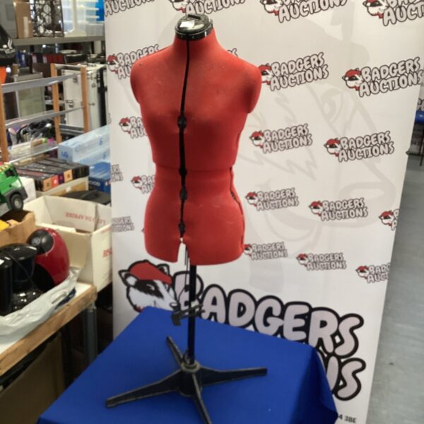 Red male mannequin torso on a metal base for clothing display.