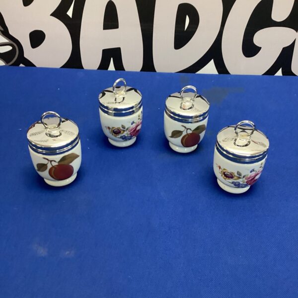 Set of four vintage Royal Worcester egg coddlers with floral design.