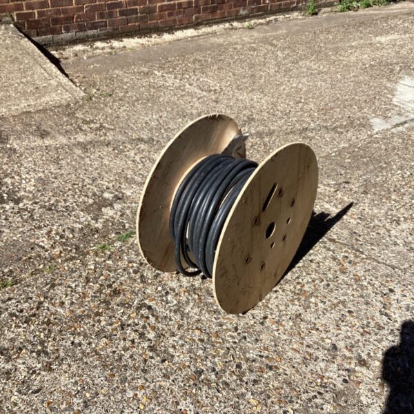 Wooden drum of heavy-duty armoured electrical cable for industrial use.