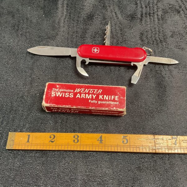 Vintage Wenger Swiss Army Knife in red handle, collectible multi-tool.
